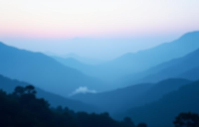 Serene view of mist-covered mountains at dawn.
